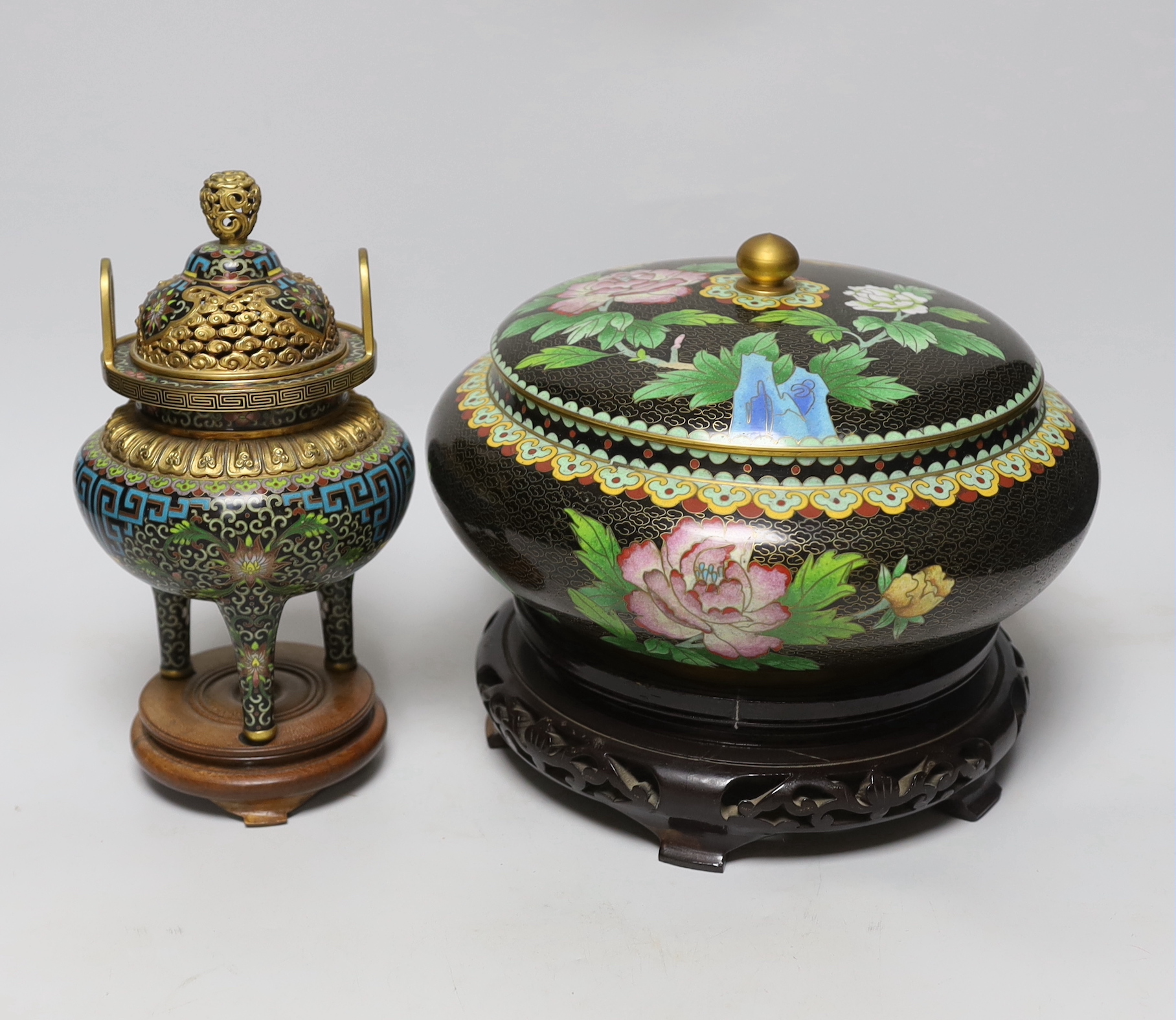 A Chinese cloisonné enamel three footed vase and cover together with a censer and cover, each raised on hardwood stands, the largest 26cm in diameter